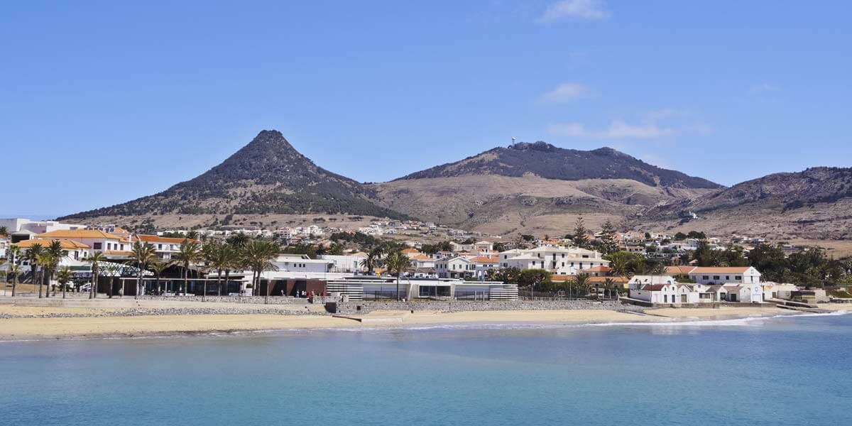 A body of water with Porto Santo Island in the background