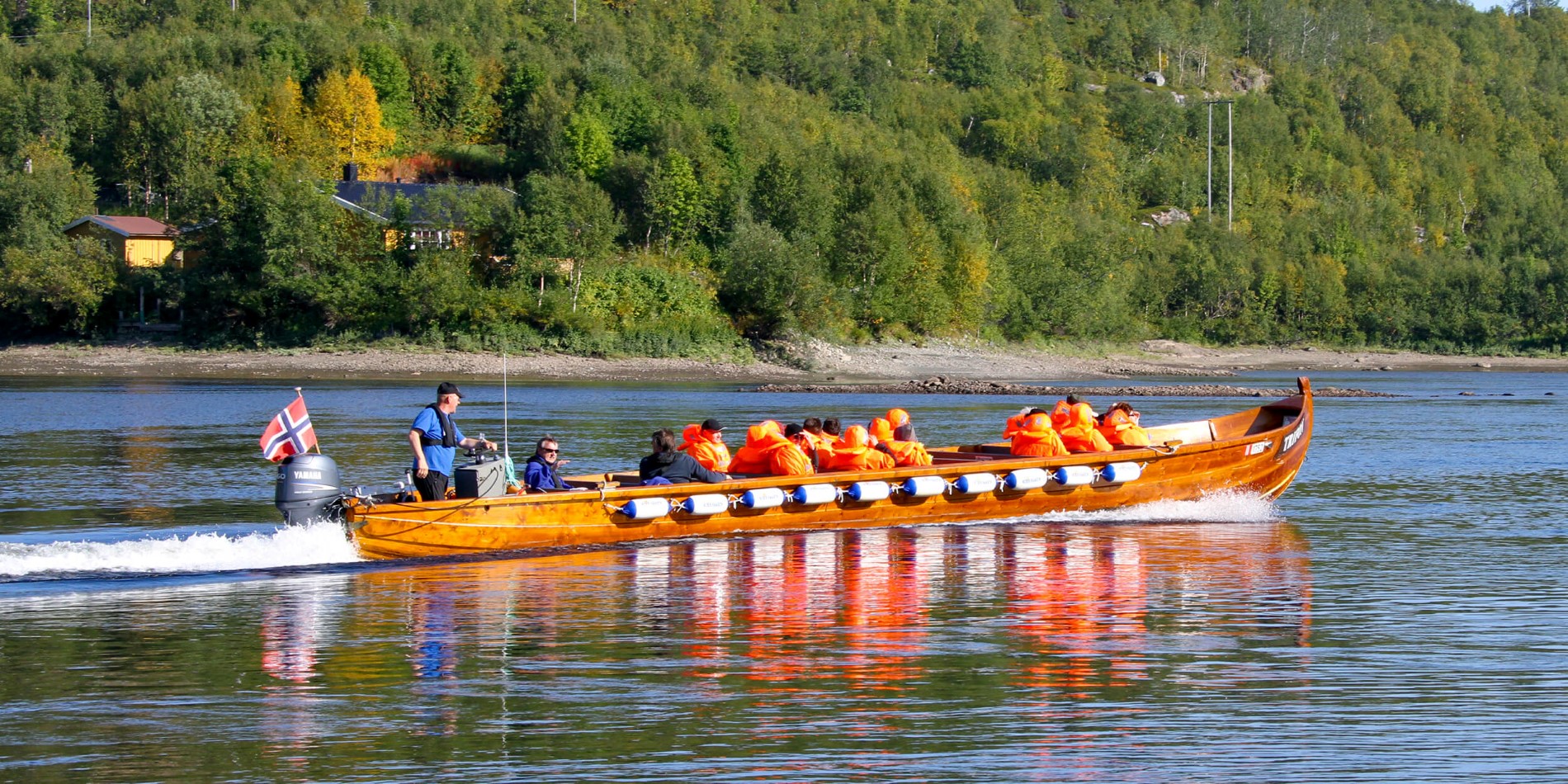 A group of people riding on the back of a boat in the water