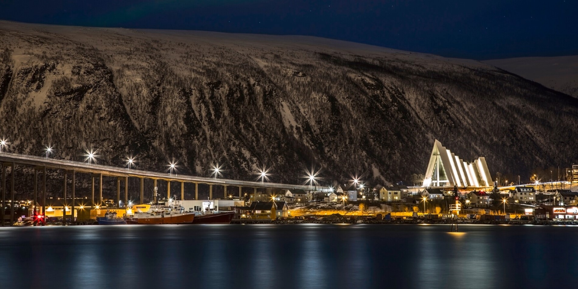 The Arctic Cathedral seen from Tromsøya. Its dark and the bridge and cathedral is lighting up the dark night