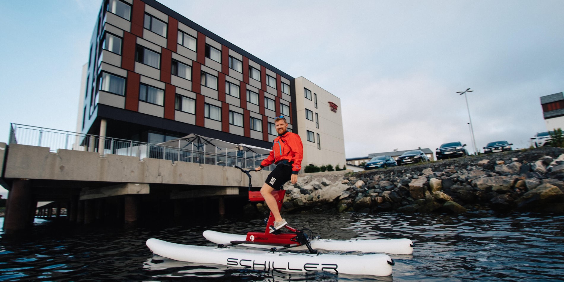 A man riding on the back of a boat next to a building